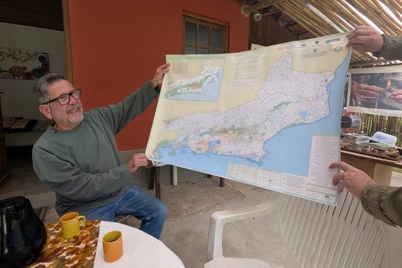 a brazilian man holds up a map of rio de janeiro state