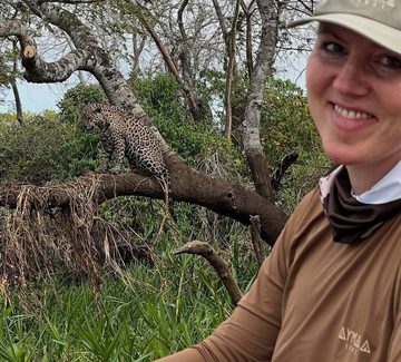female guide smiling for the camera with a jaguar in the background