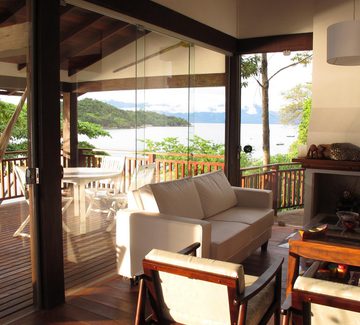 a living room and terrace overlooking the sea near paraty