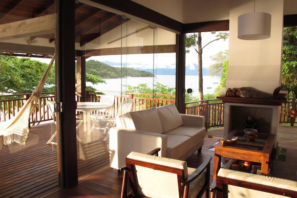 a living room and terrace overlooking the sea near paraty