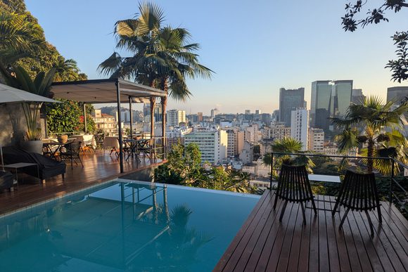 morning light on a swimming pool and breakfast terrace overlooking the historic centre in rio