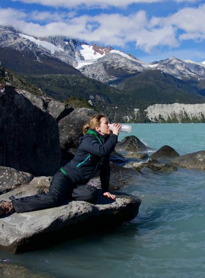 Chile patagonia carretera austral woman drinking from leones lagoon c pura aventura thomas power