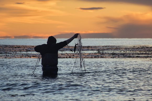 man fishing at sunrise in strait of magellan