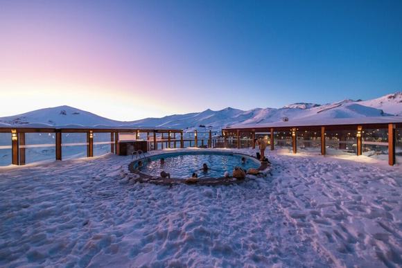 group of skiers in hot tub surrounded by snow
