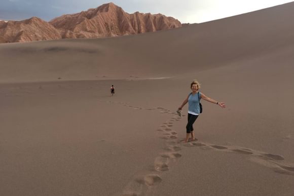 lady running down sand dune in atacama