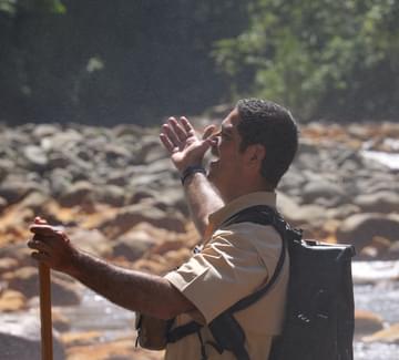smiling male guide with arms spread wide amid the rivers of bajos del toro