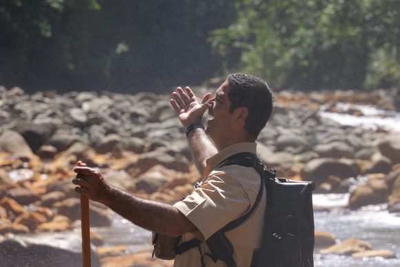 smiling male guide with arms spread wide amid the rivers of bajos del toro