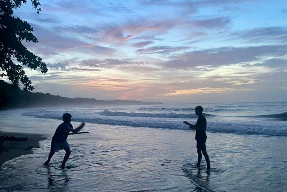 children playing on caribbean beach in costa rica