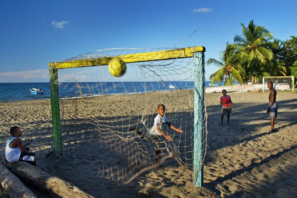boys playing footbal on beach in costa rica