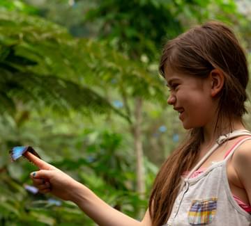 girl with morpho butterfly on finger