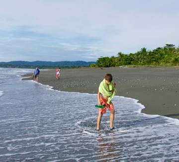 boys and grandfather walking on wild pacfic beach on the osa peninsula