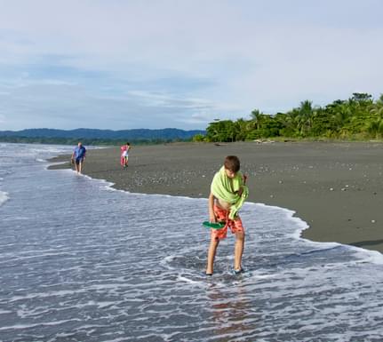 Costa rica osa peninsula casa atrevida boys with grandfather walking on beach