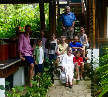 a family with people ranging from young children to granparents pose for a photo outside a beachside house in the forests of the osa peninsula
