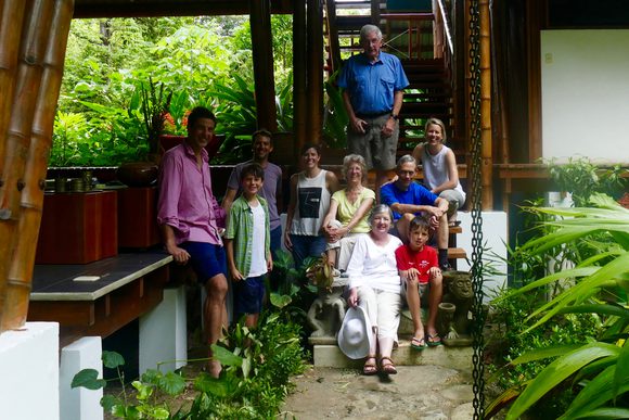 a family with people ranging from young children to granparents pose for a photo outside a beachside house in the forests of the osa peninsula