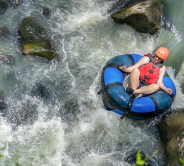 a lady on a river tube in a river canyon in costa rica