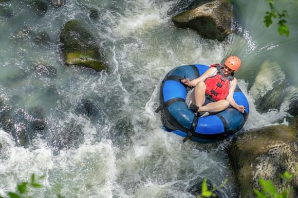 a lady on a river tube in a river canyon in costa rica