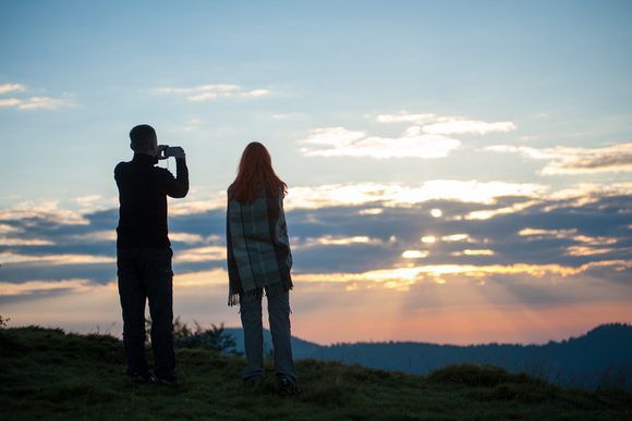couple hikers hill sunset