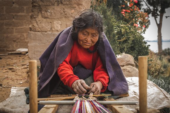 andean lady on island in lake titicaca