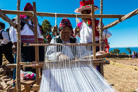 Peru lake titicaca men weaving in the peruvian andes at taquile island on puno peru