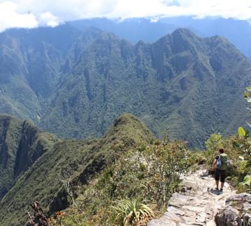man sitting at sun gate above machu picchu