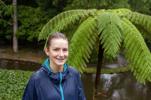 girl smiling next ot fern in furnas, sao miguel