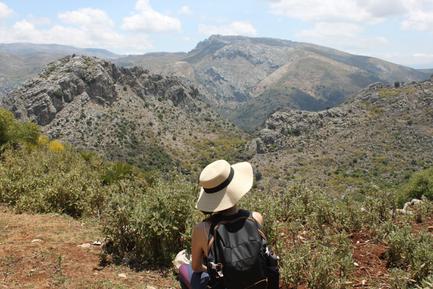 woman in hat looking over mountain scenery in grazalema