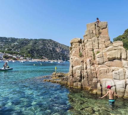 Spain catalonia aiguablava beach with sunbathers while a boat is heading to the beach in costa brava j2r