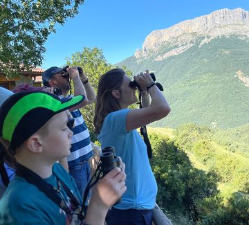 a family of travellers look through binoculars in ordesa national park