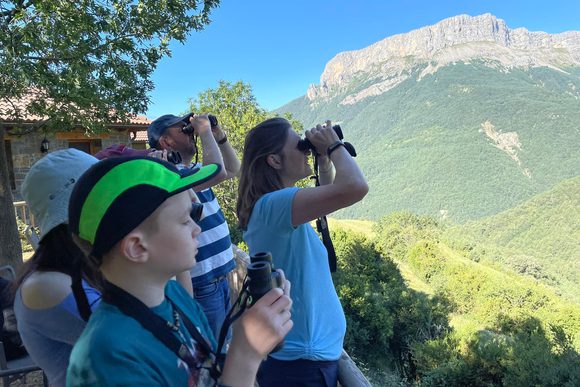 a family of travellers look through binoculars in ordesa national park