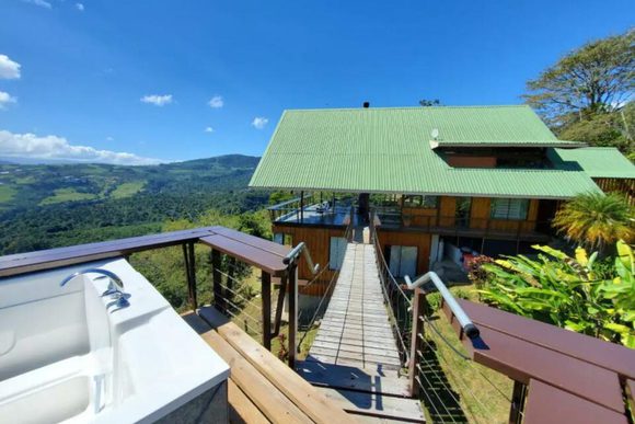 a view of a hot tub and house perched above the clouds in costa rica's central valley